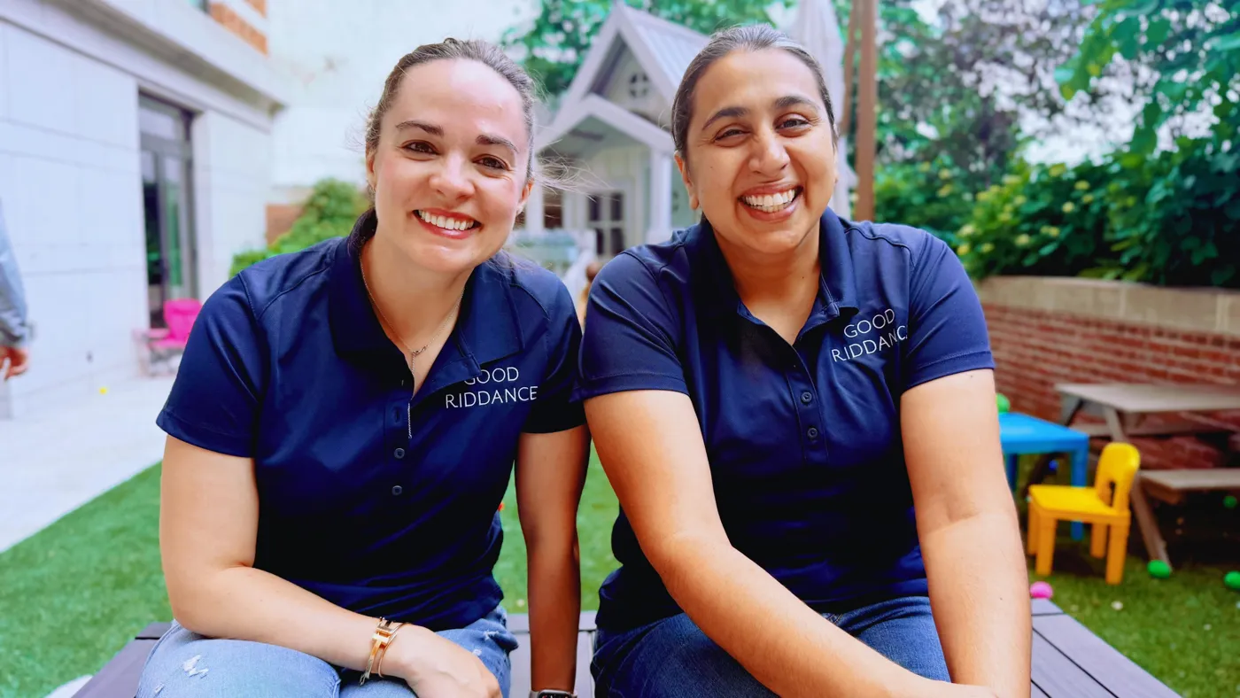 Cortney Boston and Anita Kohli, co-founders of Good Riddance, smiling in navy Good Riddance polo shirts